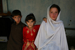A student supported by Hashoo Foundation in a school in Chitral sits next to her niece and nephew in their house.